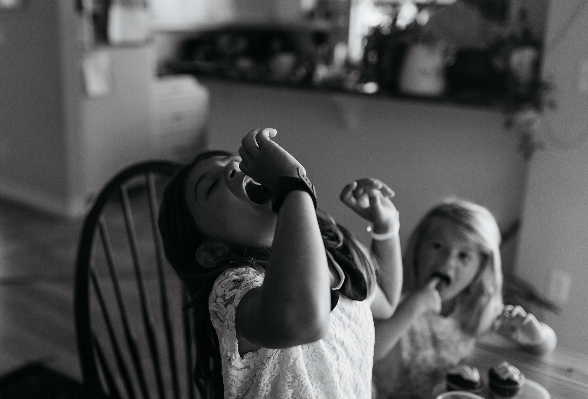 black and white photo of girl eating cupcake decorations