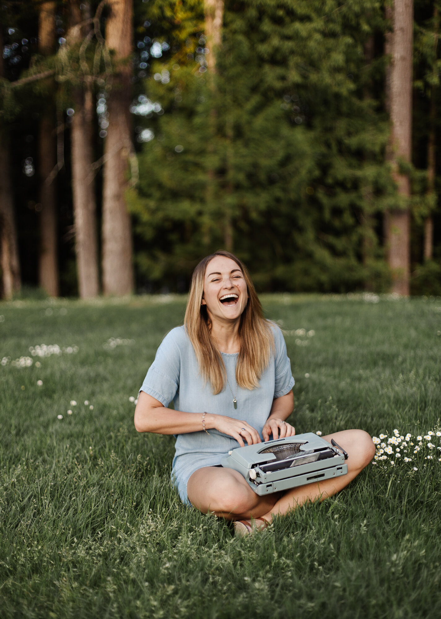 Woman laughing while sitting on the grass with her typewriter | Tell the story behind your business | Kristen Turner MacDonald | Cowichan Valley Photographer