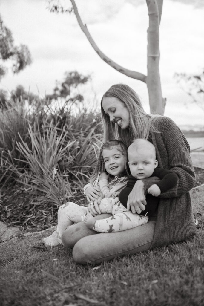 Black and white photo of mum with her two children in the park