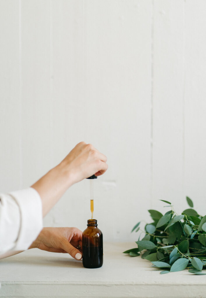 Naturopath using brown glass bottle with a dropper to make a tonic