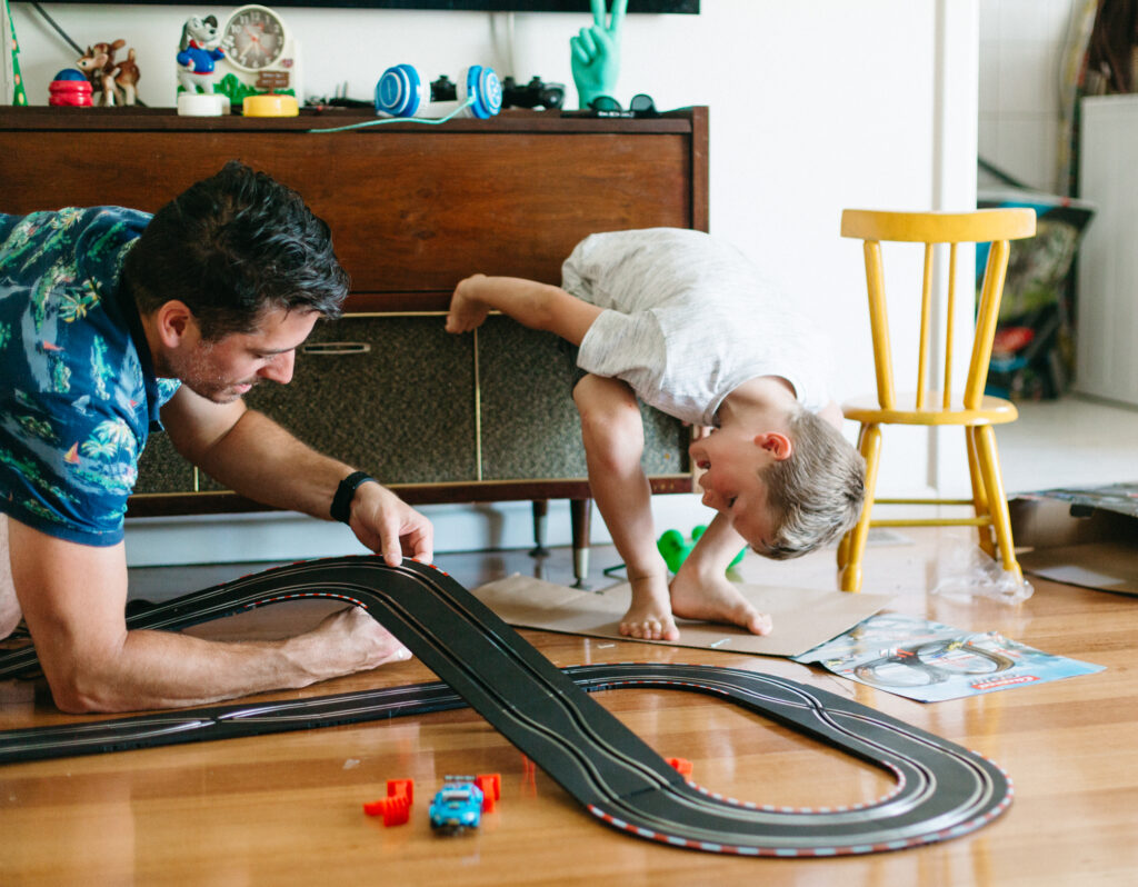 Little boy sets up racing car tracks on Christmas Day in Melbourne.