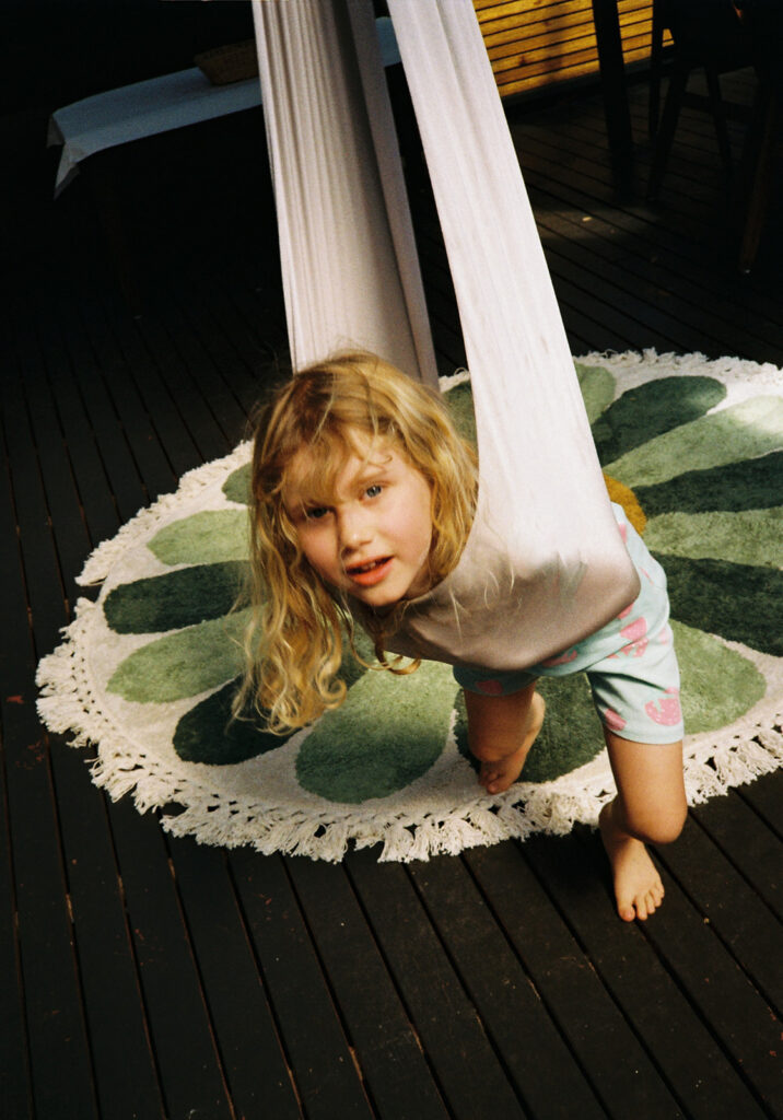 little girl playing in aerial yoga silk during a film family session in geelong
